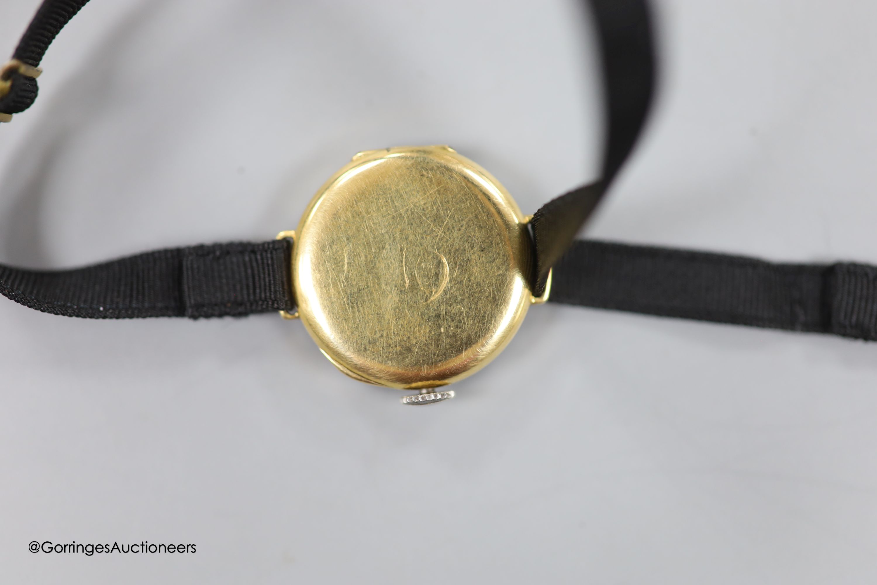 A lady's early 20th century 18ct gold, black onyx and diamond set cocktail watch, case diameter 21mm, on a fabric strap, gross weight 11.3 grams.